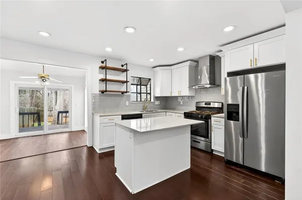 a kitchen with stainless steel appliances granite countertop a refrigerator a sink dishwasher a stove and a refrigerator