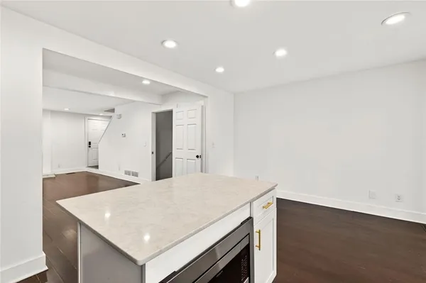 a kitchen with a sink a microwave and cabinets