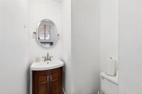 a bathroom with a toilet a sink and mirror