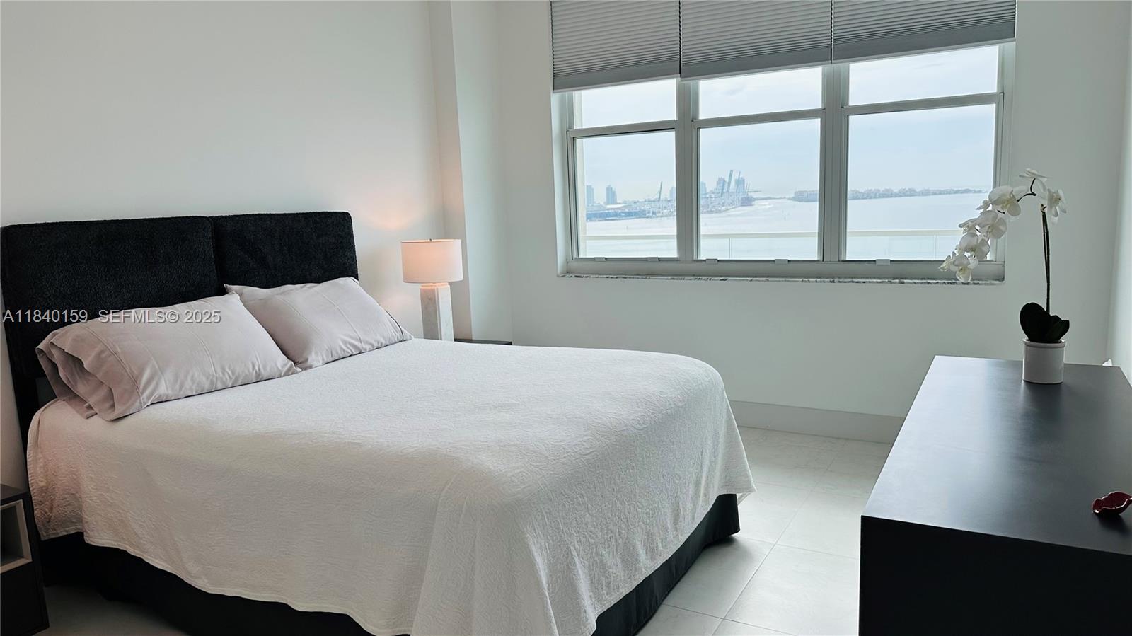 800 Claughton Island Drive, Unit 1903 Miami, FL 33131 - Photo 12 of 34 a bedroom with a bed and a window