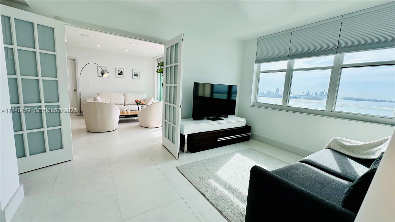 800 Claughton Island Drive, Unit 1903 Miami, FL 33131 - Photo 13 of 34 a living room with furniture and a flat screen tv