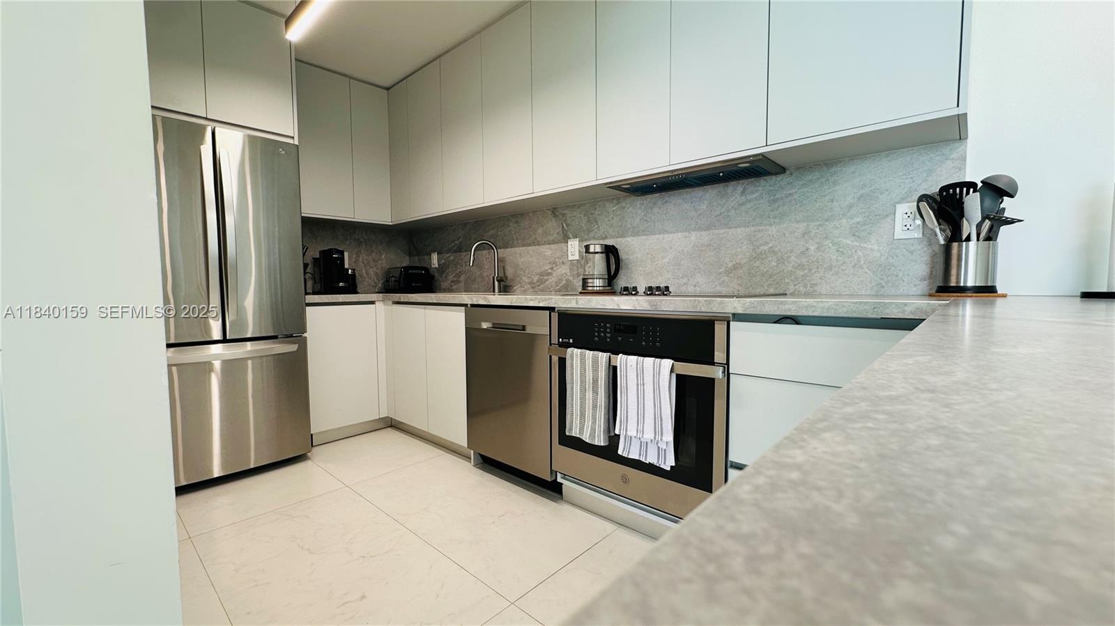 800 Claughton Island Drive, Unit 1903 Miami, FL 33131 - Photo 15 of 34 a kitchen with stainless steel appliances granite countertop a refrigerator a stove and a sink