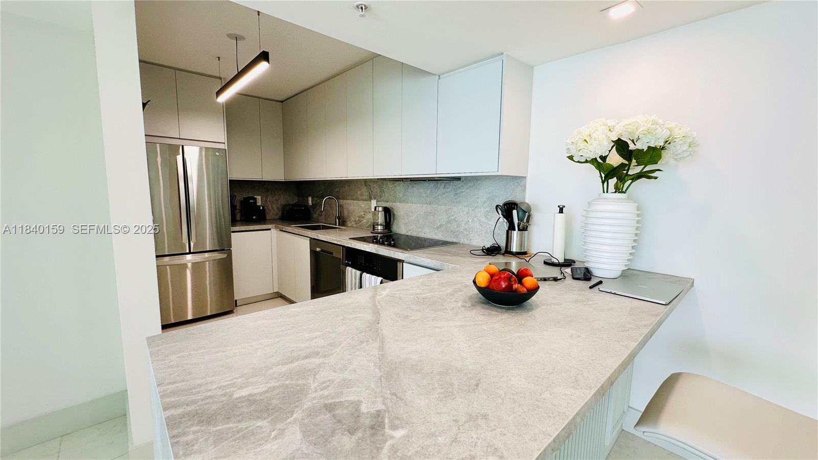 800 Claughton Island Drive, Unit 1903 Miami, FL 33131 - Photo 18 of 34 a kitchen with stainless steel appliances a counter space and cabinets