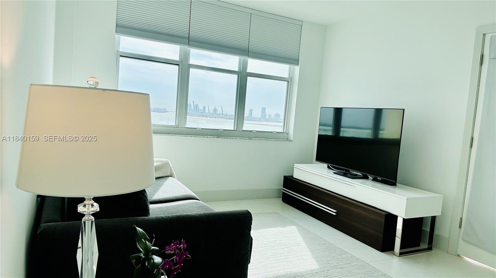 800 Claughton Island Drive, Unit 1903 Miami, FL 33131 - Photo 23 of 34 a living room with furniture and a flat screen tv