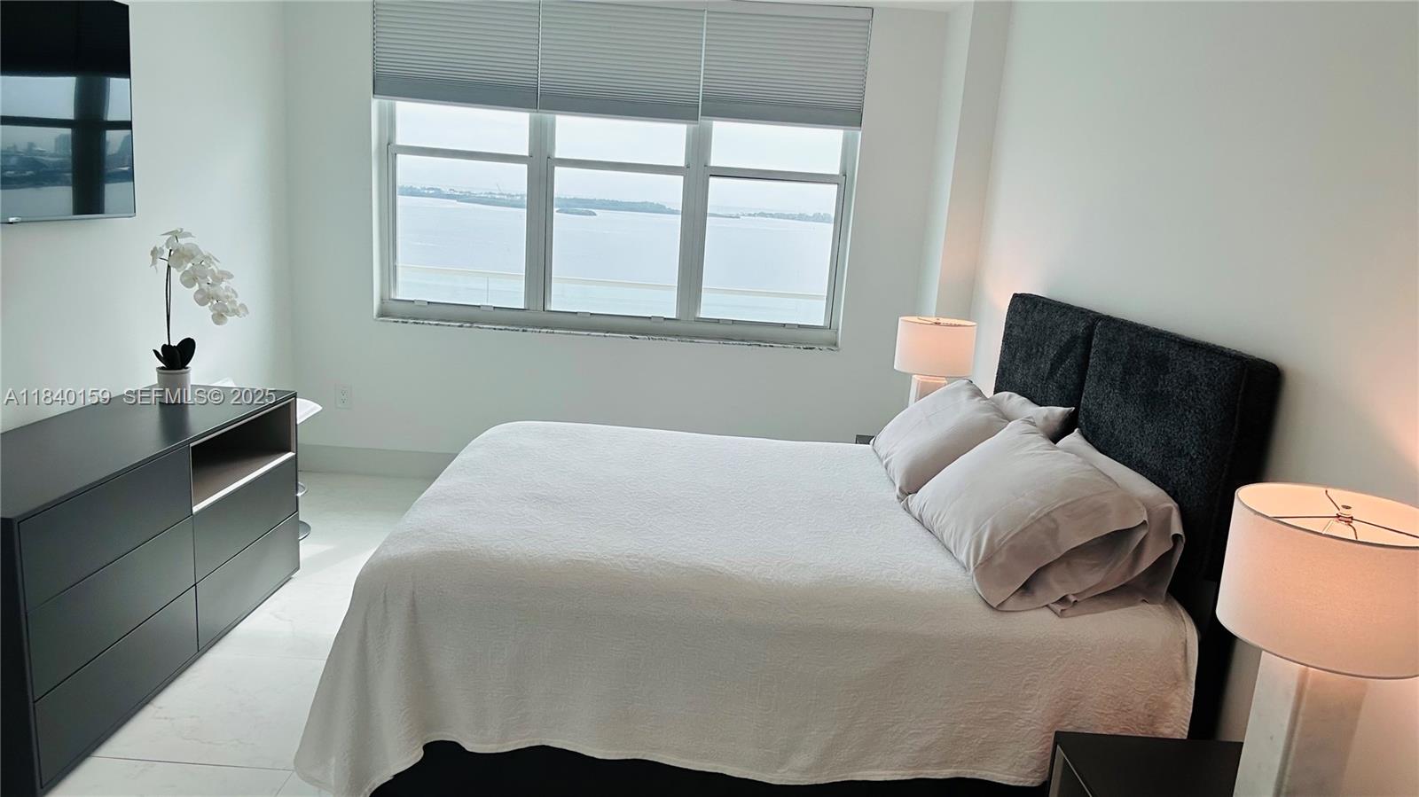 800 Claughton Island Drive, Unit 1903 Miami, FL 33131 - Photo 27 of 34 a bedroom with a bed and wooden floor