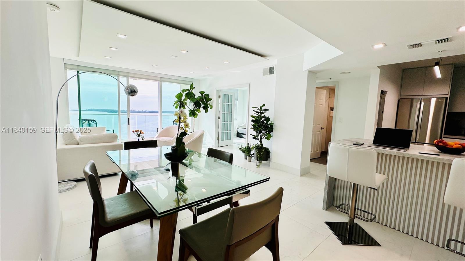 800 Claughton Island Drive, Unit 1903 Miami, FL 33131 - Photo 7 of 34 a view of a dining room with furniture and a potted plant