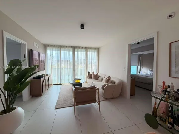 a living room with furniture potted plant and flat screen tv