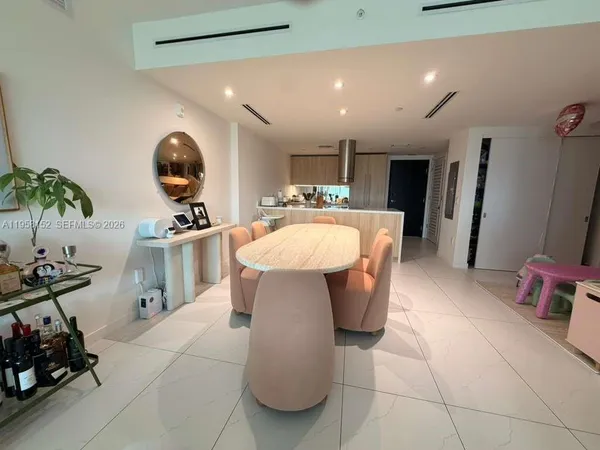 a kitchen with stainless steel appliances a table and chairs in it