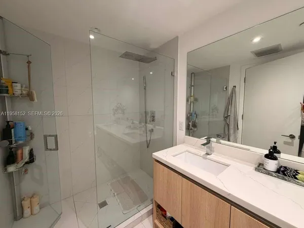 a bathroom with a shower sink and mirror