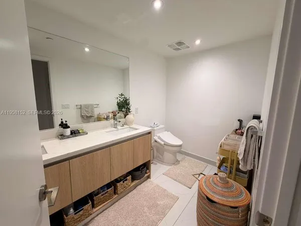 a bathroom with a sink a toilet and a mirror
