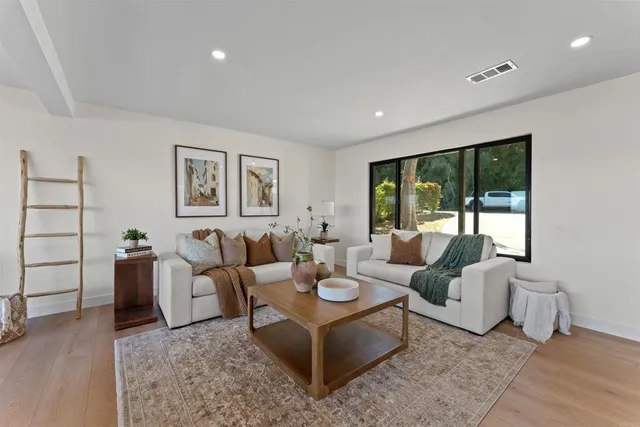 a living room with furniture and large windows