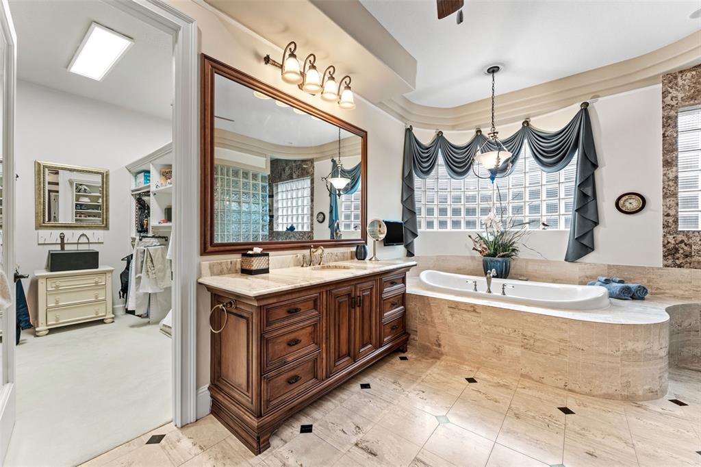 5070 Down Point Lane Windermere, FL 34786 - Photo 34 of 57 a bathroom with a sink vanity granite tub and a large mirror