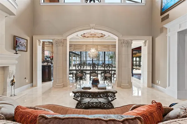 a living room with furniture a chandelier and a fireplace