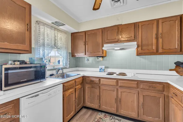 a kitchen with a sink dishwasher stove and cabinets