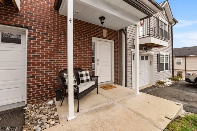 a view of a house with a door and wooden bench