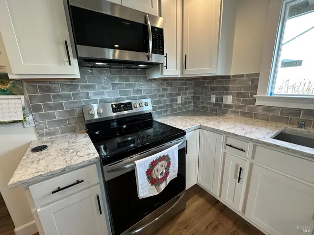 a kitchen with stainless steel appliances granite countertop a sink stove and cabinets