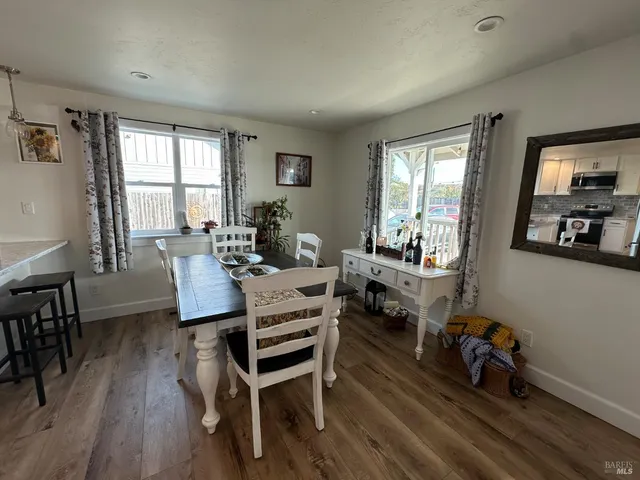 a kitchen with stainless steel appliances kitchen island granite countertop a stove a sink a refrigerator and white cabinets