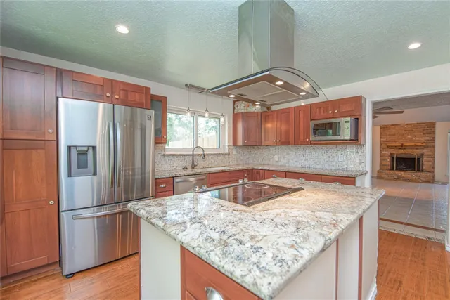 a kitchen with stainless steel appliances granite countertop a sink refrigerator and microwave