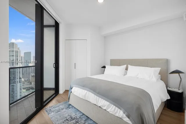 a bedroom with a balcony a bed and walk in closet