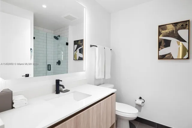 a bathroom with a sink toilet and mirror