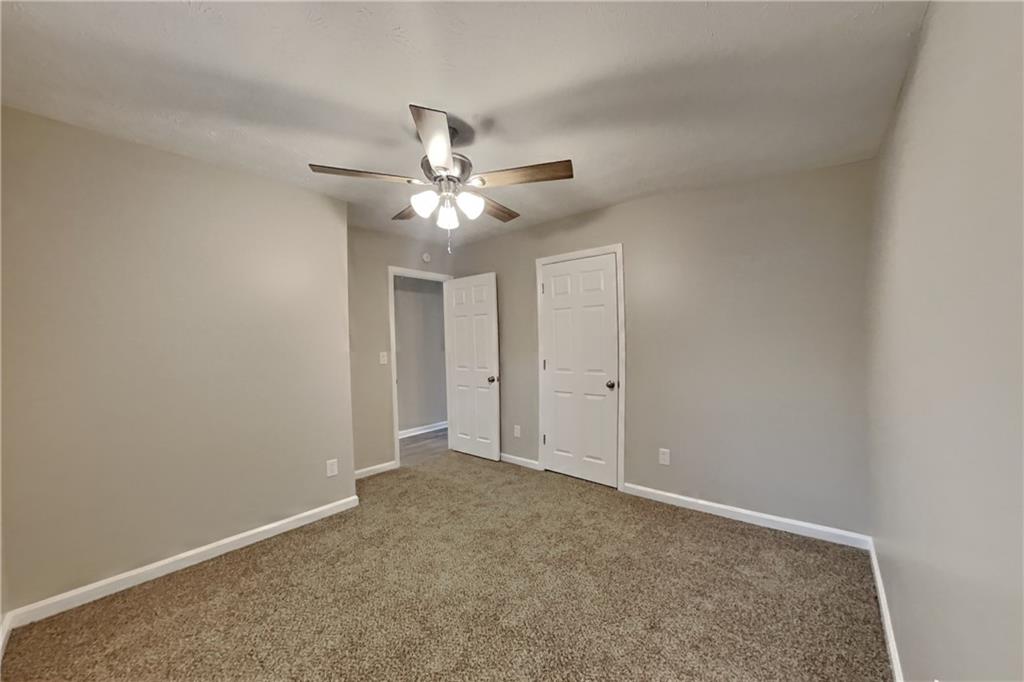 5105 North Bridges Drive Alpharetta, GA 30022 - Photo 11 of 21 an empty room with a chandelier fan and windows