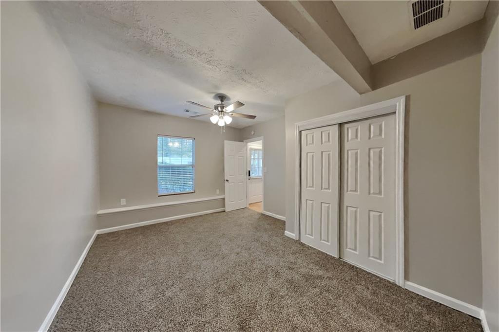 5105 North Bridges Drive Alpharetta, GA 30022 - Photo 10 of 21 an empty room with chandelier fan and windows