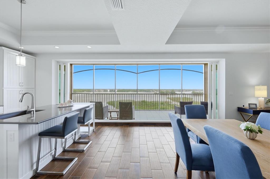 10510 Boardwalk Loop, Unit 602 Lakewood Ranch, FL 34202 - Photo 13 of 77 a large kitchen with kitchen island a large window in it and a dining table