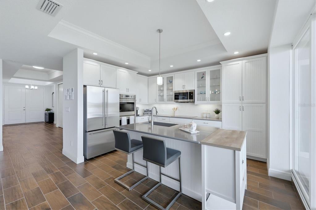10510 Boardwalk Loop, Unit 602 Lakewood Ranch, FL 34202 - Photo 23 of 77 a kitchen with stainless steel appliances granite countertop a stove a sink a refrigerator and cabinets