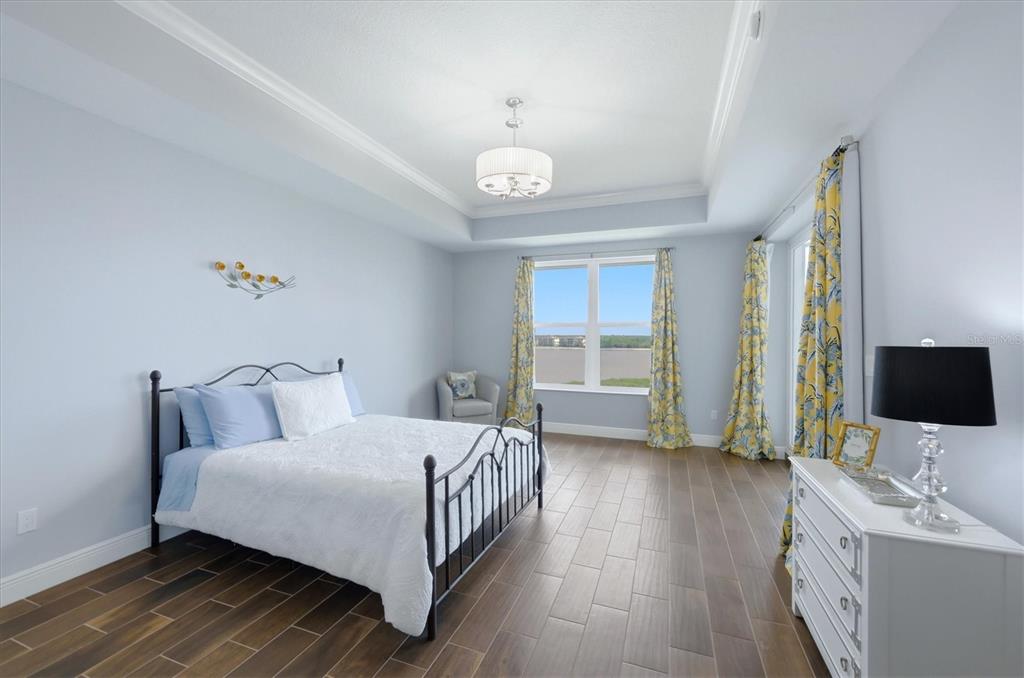 10510 Boardwalk Loop, Unit 602 Lakewood Ranch, FL 34202 - Photo 28 of 77 a bedroom with a bed and a flat tv screen on dresser