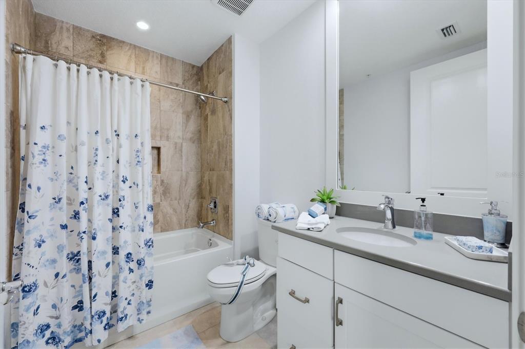 10510 Boardwalk Loop, Unit 602 Lakewood Ranch, FL 34202 - Photo 34 of 77 a bathroom with a double vanity sink toilet mirror and shower