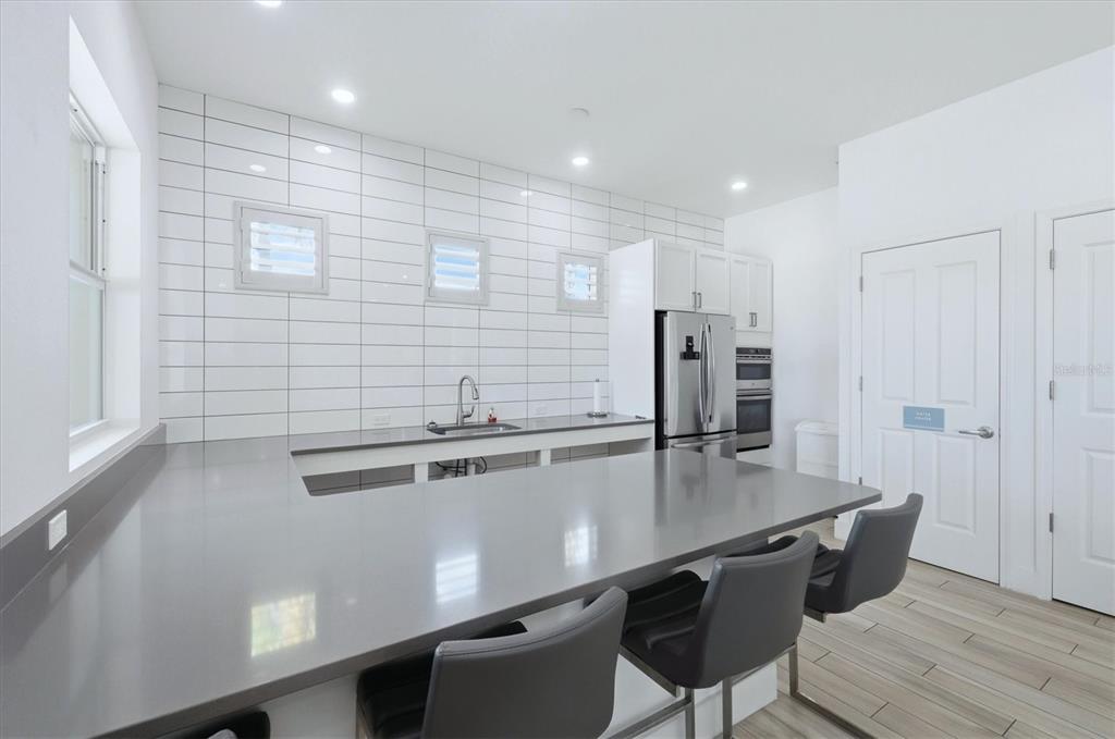 10510 Boardwalk Loop, Unit 602 Lakewood Ranch, FL 34202 - Photo 51 of 77 a kitchen with stainless steel appliances a dining table chairs and refrigerator