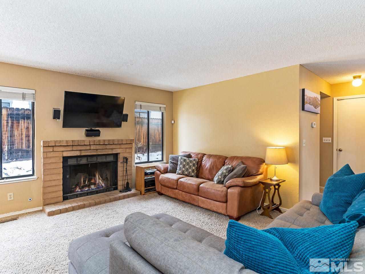 1703 Terrace Heights Lane Reno, NV 89523 - Photo 5 of 13 a living room with furniture a flat screen tv and a fireplace