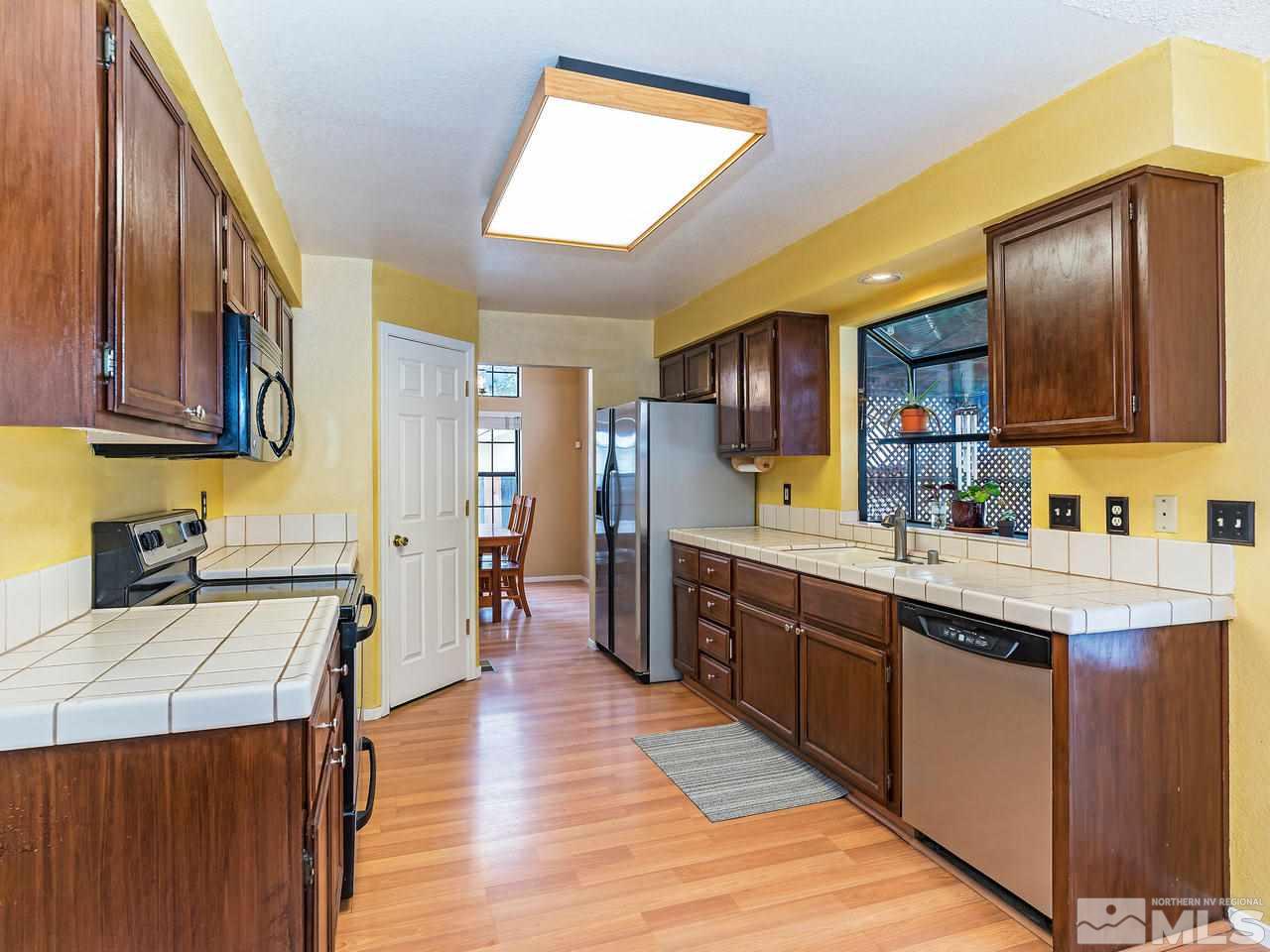 1703 Terrace Heights Lane Reno, NV 89523 - Photo 8 of 13 a kitchen with stainless steel appliances granite countertop wooden cabinets a sink and dishwasher a stove with wooden floors