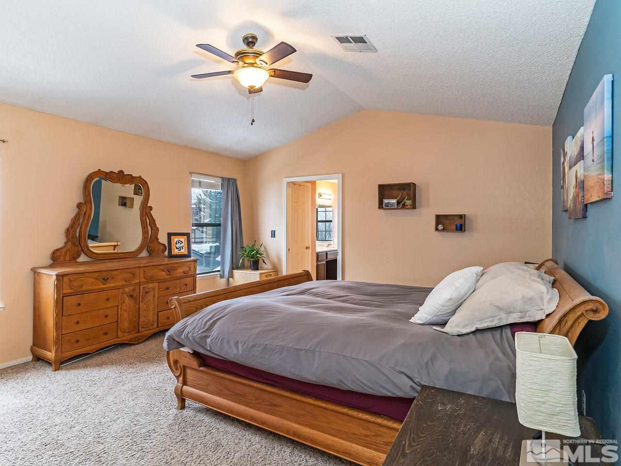 1703 Terrace Heights Lane Reno, NV 89523 - Photo 9 of 13 a bedroom with a bed and a chandelier