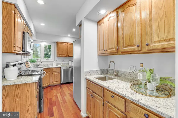 a open kitchen with stainless steel appliances granite countertop a stove and a wooden floors