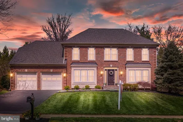 front view of a brick house with potted plants