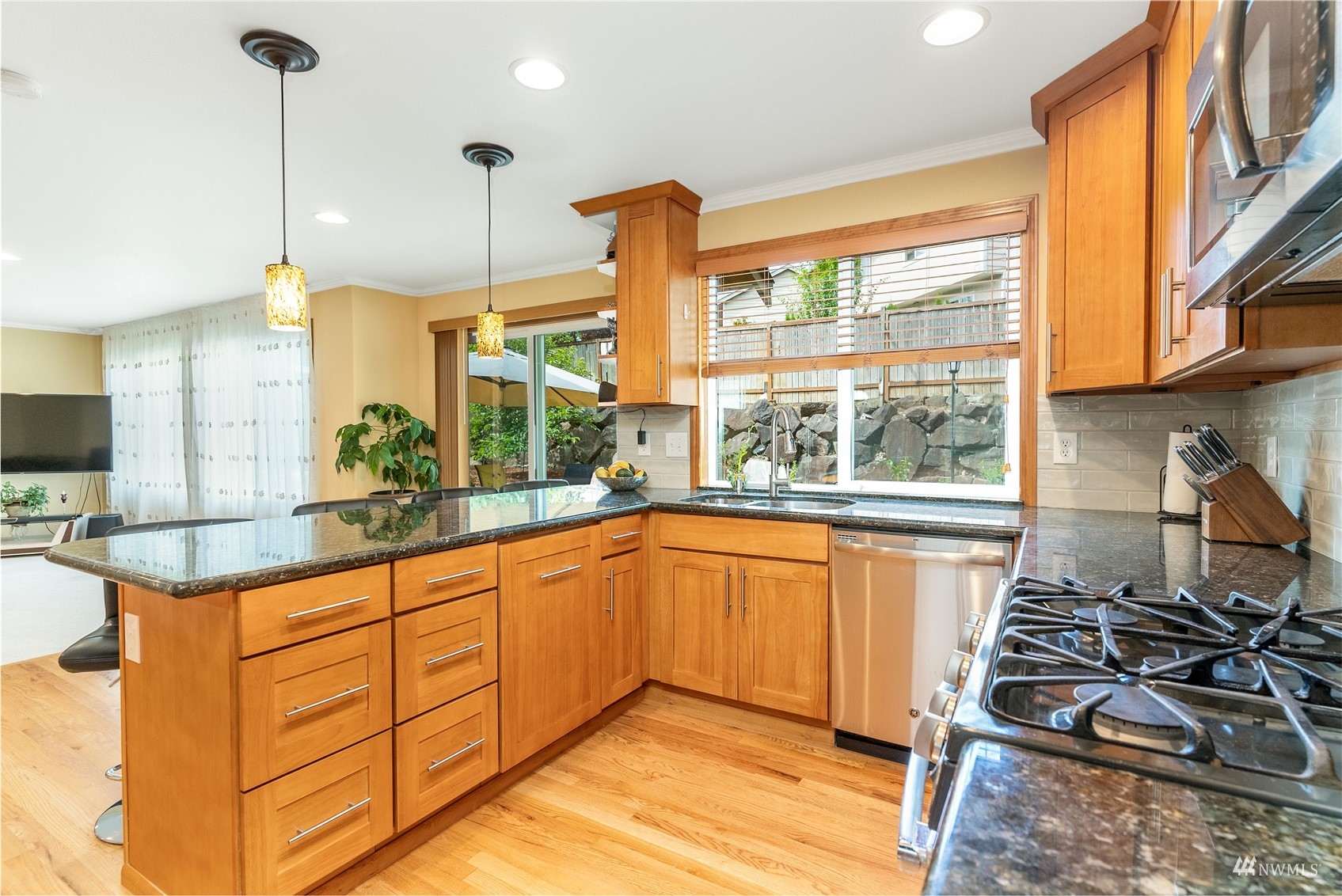 1807 Field Avenue Northeast Renton, WA 98059 - Photo 15 of 38 a kitchen with stainless steel appliances kitchen island granite countertop a stove a sink and white cabinets next to a window
