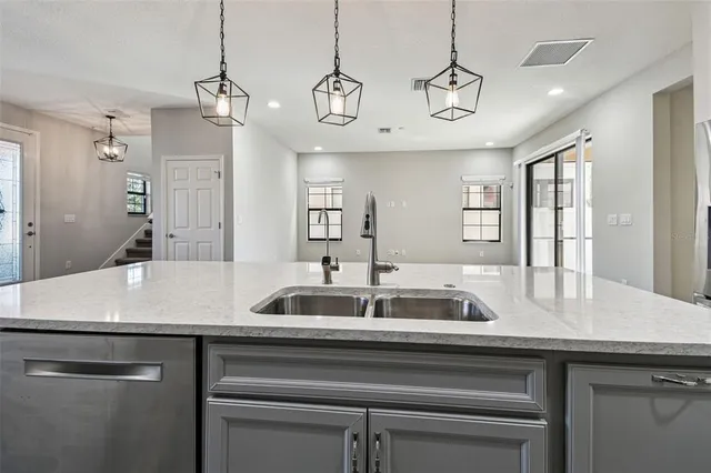 a large kitchen with kitchen island a stove a sink and a wooden floor