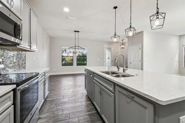 a kitchen with stainless steel appliances kitchen island a refrigerator sink and cabinets