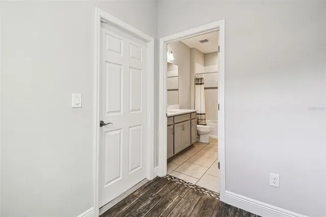 a view of a hallway with wooden floor and staircase