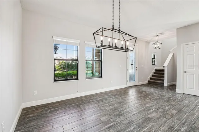 an empty room with windows and ceiling fan
