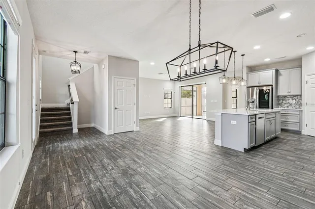 a large kitchen with stainless steel appliances kitchen island granite countertop a large counter top and a stove