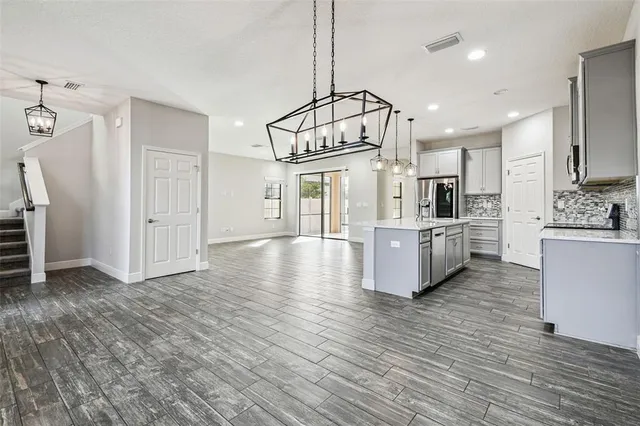a kitchen with stainless steel appliances granite countertop a sink stove microwave and refrigerator