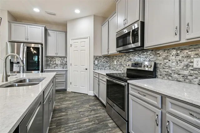 a kitchen with stainless steel appliances granite countertop a sink stove and microwave