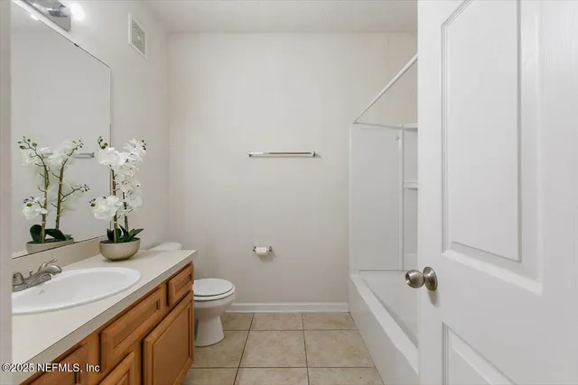 a bathroom with a granite countertop sink a toilet and shower