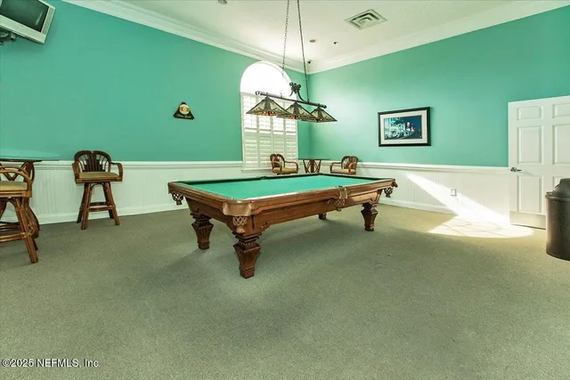 a room with pool table and windows