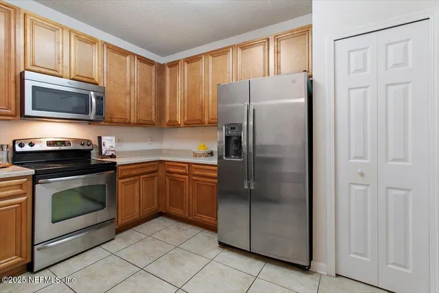 a kitchen with stainless steel appliances granite countertop a refrigerator stove and microwave