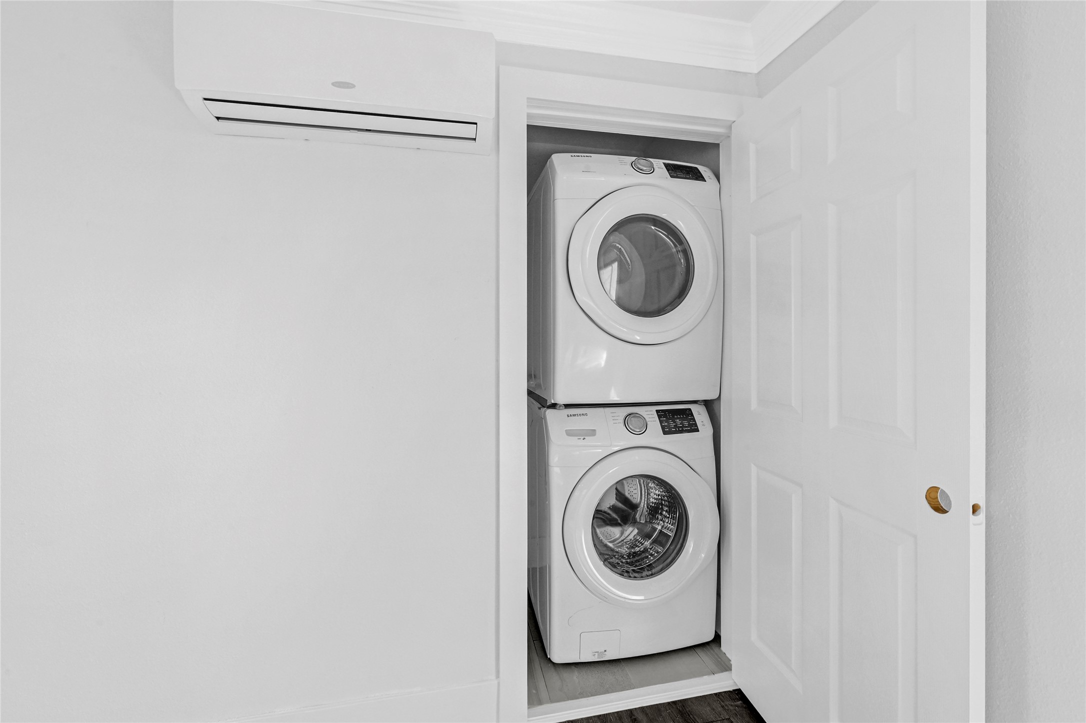 1633 Fourcade Street, Unit C Houston, TX 77023 - Photo 5 of 7 This photo shows a compact laundry area with a stacked washer and dryer set inside a closet with sliding doors, maximizing space efficiency.