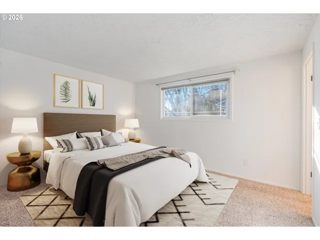 a bedroom with a bed window and painting on the wall