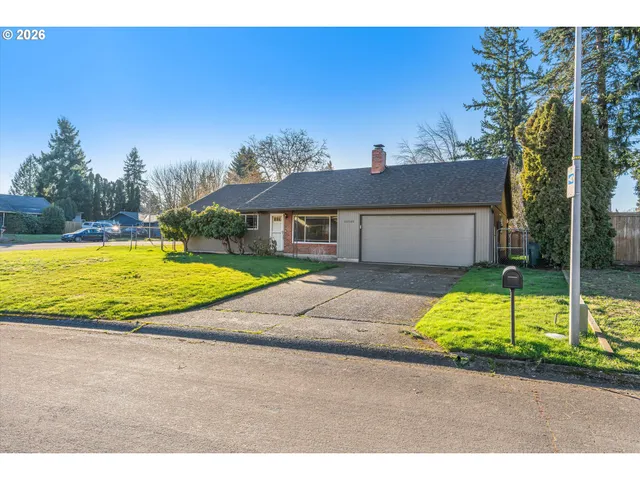 a view of a house with backyard and tree